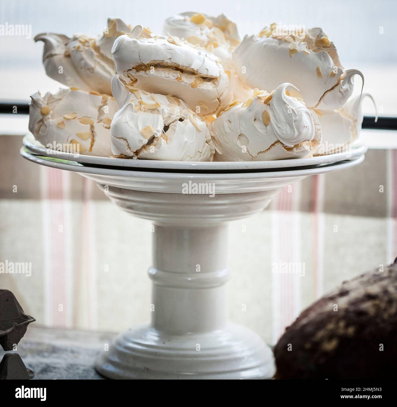 Meringhe incredibili su un supporto per torte in una finestra di delicatessen Foto Stock