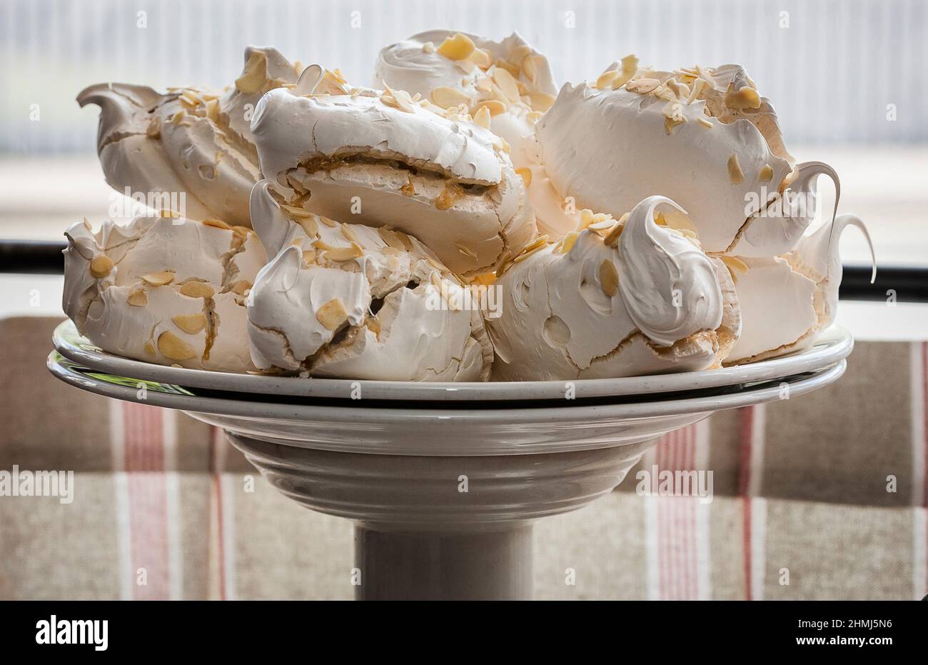 Meringhe incredibili su un supporto per torte in una finestra di delicatessen Foto Stock