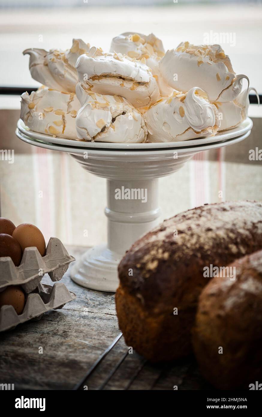 Meringhe incredibili su un supporto per torte in una finestra di delicatessen Foto Stock