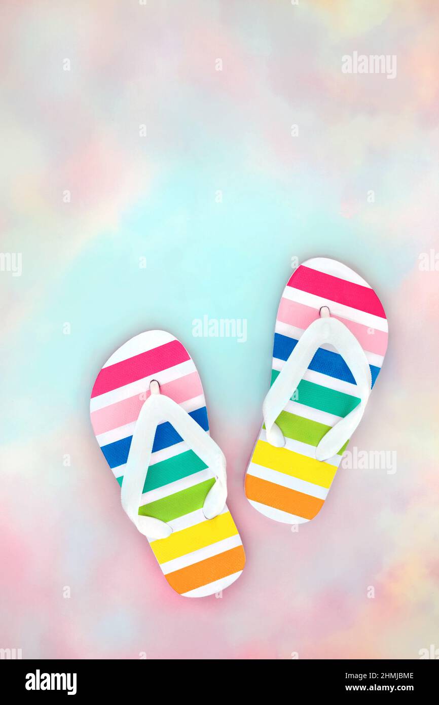 Rainbow flip flop su sfondo pastello rosa blu cielo nuvola. Viaggi, turismo, vacanza, divertimento e LGBT concetto. Spazio di copia. Foto Stock