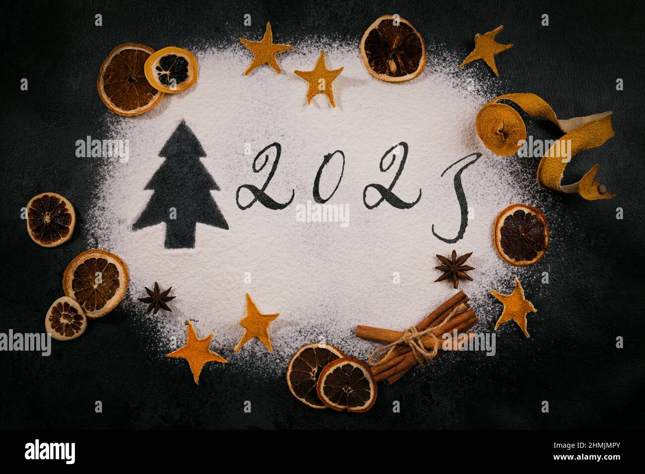 Albero di Natale e 2023 disegnato sulla farina frantumata su sfondo nero, accessori da forno e ingredienti. Buon Natale e felice anno nuovo 2023. Foto Stock