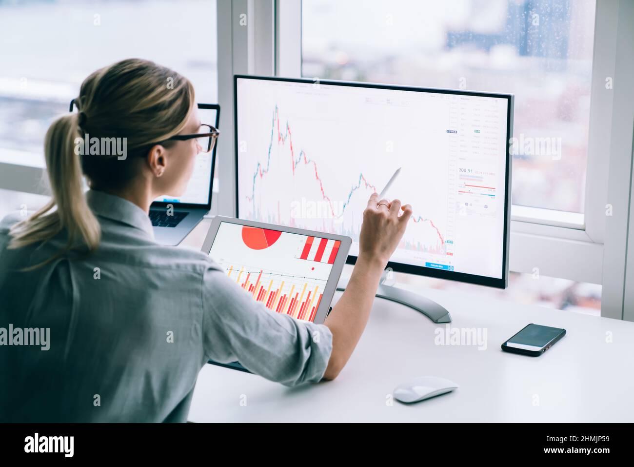 Trader irriconoscibile che analizza il grafico sullo schermo del computer in ufficio Foto Stock
