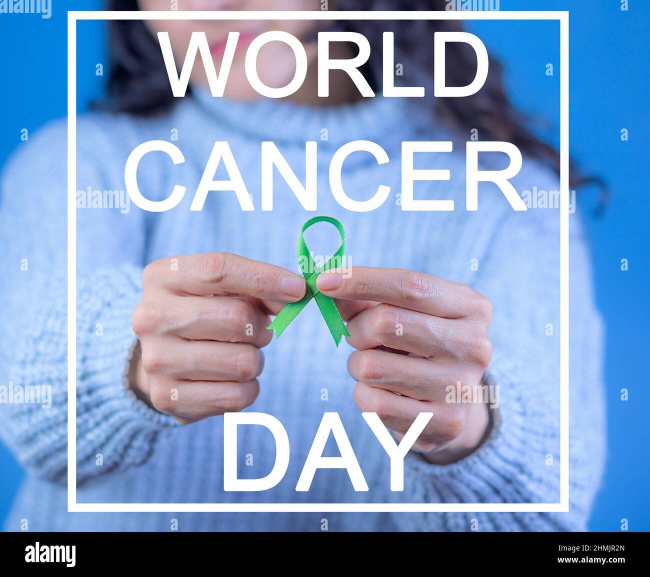 Nastro verde per supportare la consapevolezza del cancro del fegato e surrenale, mani umane che tengono nastro verde. Giornata mondiale del cancro. Testo con la leggenda: 'Cancro del mondo da Foto Stock