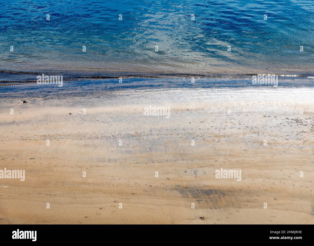 Primo piano di onde dolci che lambiscono la riva. Foto Stock