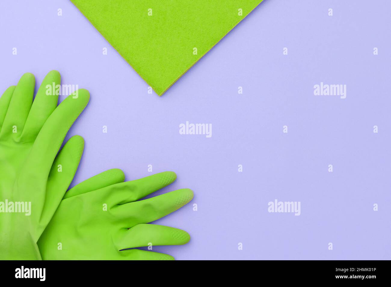 Guanto da cucina verde e un panno verde per la pulizia su sfondo viola. Foto Stock