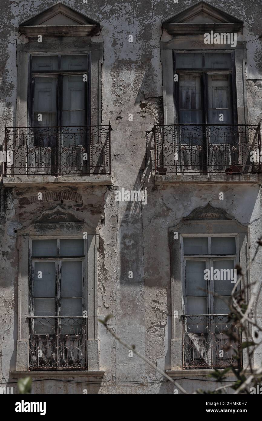 Lunga casa cittadina a bandoned facciata scheggiata-balconi chiusi e balconi-ringhiere in metallo. Tavira-Portogallo-094 Foto Stock