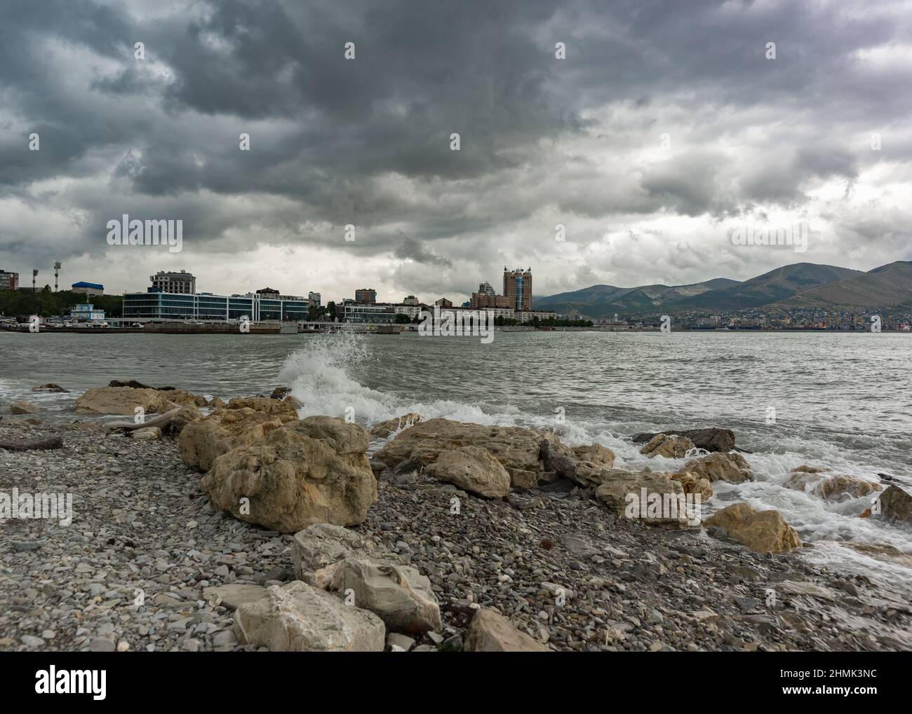 Novorossiysk, Russia, 13 agosto 2021: Un'onda si tuffa contro la costa rocciosa della baia di Tsemesskaya. Nuvoloso giorno d'estate Foto Stock