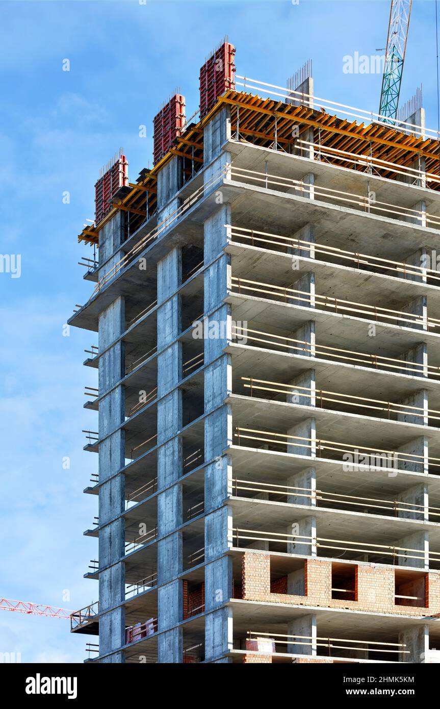 Uso di impalcature e casseforme nella moderna costruzione di strutture portanti di edifici residenziali. Immagine verticale. Foto Stock