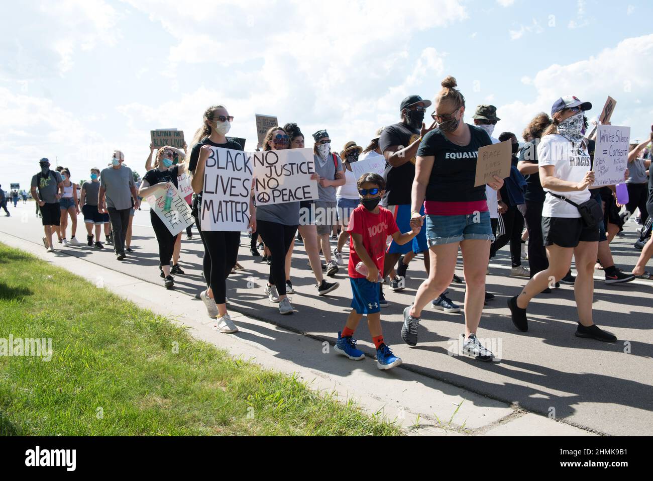 Persone di tutti i tipi di vita e di razze camminano insieme su Hall Road a Sterling Heights, Michigan 'No Justice, No Peace'. Foto Stock