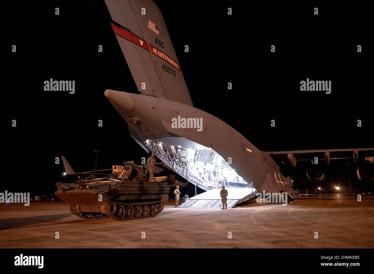 L'aeronautica degli Stati Uniti e il personale dell'esercito degli Stati Uniti caricano un velivolo 167th dell'ala C-17 di Airlift III con un vettore modificato di M113 corazzato del personale durante l'esercitazione la bandiera verde piccola roccia 22-03 all'aeroporto internazionale di Alessandria, Louisiana, 10 gennaio 2022. La GFLR 22-03 si è concentrata su tre articoli accreditati congiuntamente: Il ponte aereo di combattimento; la sopravvivenza, l'evasione, la resistenza e la fuga; e l'evacuazione aeromedica. (STATI UNITI Foto della Guardia Nazionale dell'aria dello staff Sgt. Tim Sencindiver) Foto Stock