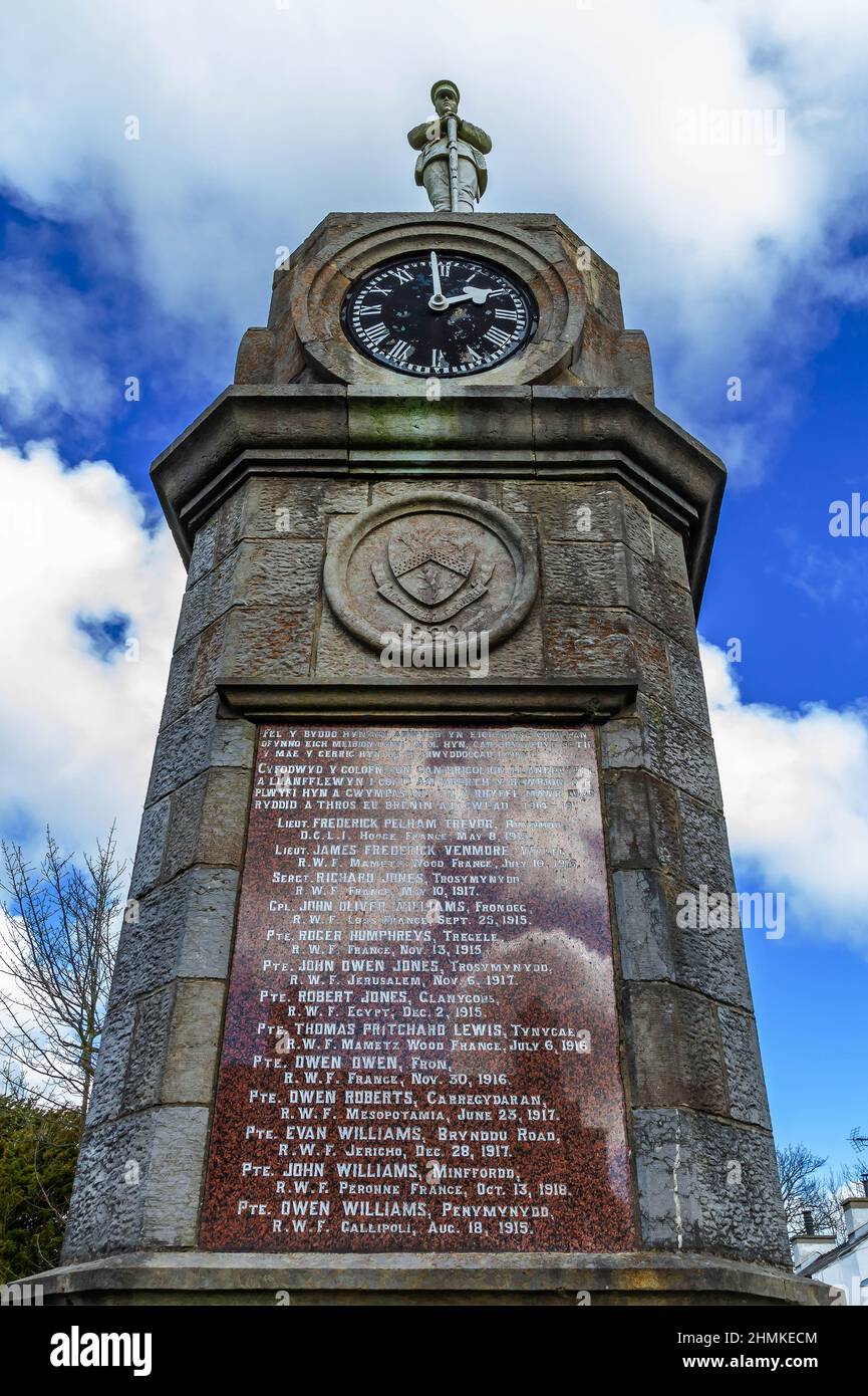 Memoriale di guerra e il Clock 1921 la medievale chiesa parrocchiale di St Mechell nel centro del villaggio di Anglesey Llanfechell Galles del Nord Foto Stock