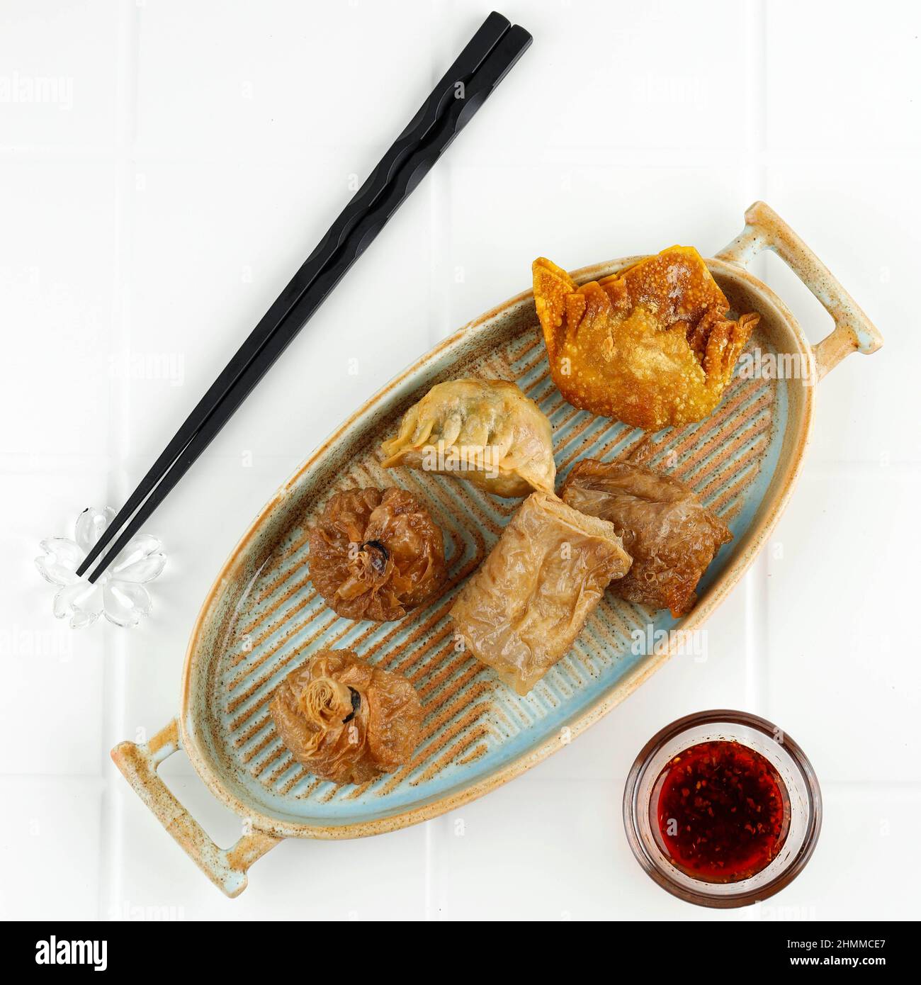 Dim Sum fritto profondo, Ekado, Lumpia su piatto ovale rustico, varie  forme, vista dall'alto su tavolo bianco Foto stock - Alamy