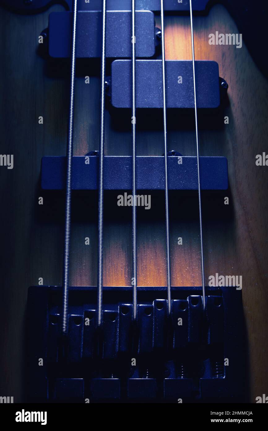 Primo piano del ponte e pickup di cinque corde di chitarra basso, forme evidenziate. Foto Stock