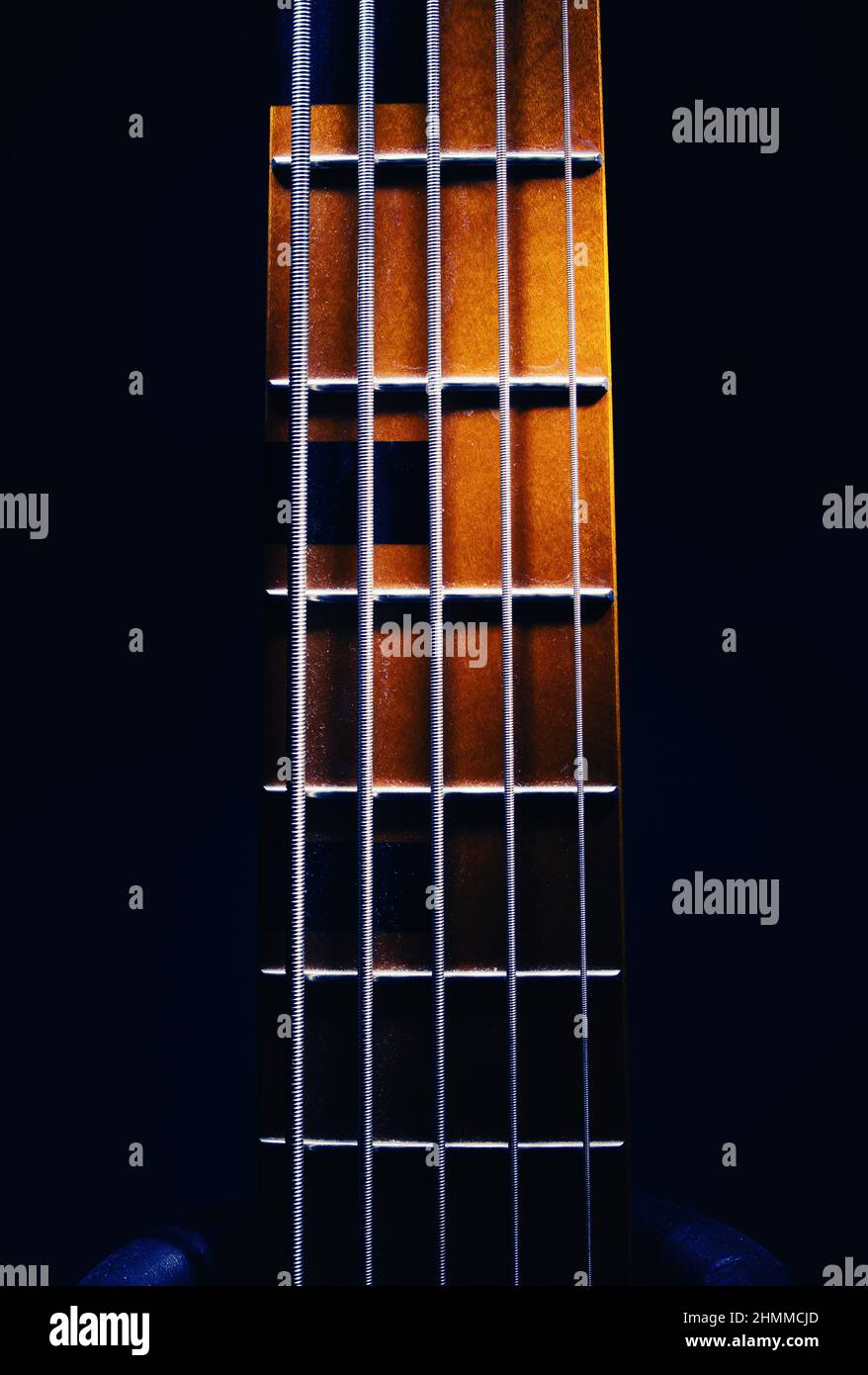 Primo piano del collo di cinque corde di chitarra basso, forme evidenziate. Foto Stock