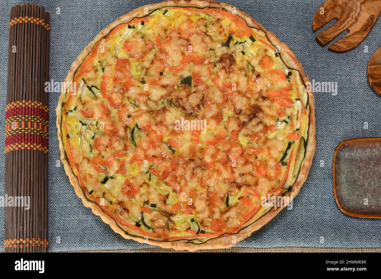 Pasto vegetariano sano. Torta vegetariana salata su un rustico tavolo di legno. Posate in legno e tovaglie etniche. Foto Stock