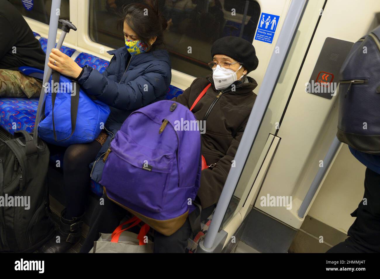 Londra, Inghilterra, Regno Unito. Metropolitana di Londra: Passeggeri che indossano maschere COVID, gennaio 2022 Foto Stock