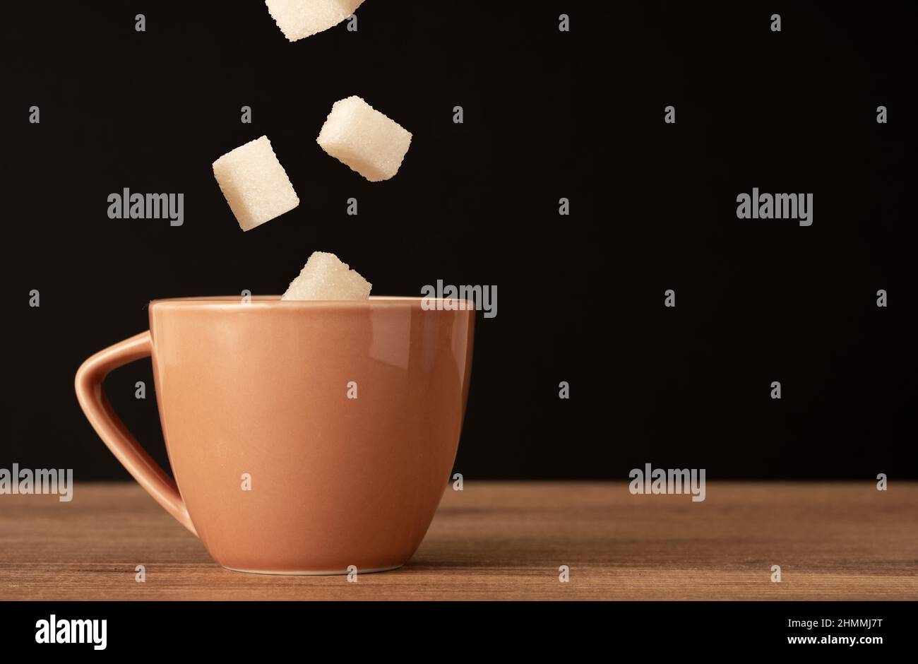 Foto ravvicinata della tazza da caffè e dello zucchero in goccia. Concetto di diabete e di eccessivo consumo di zucchero. Foto Stock