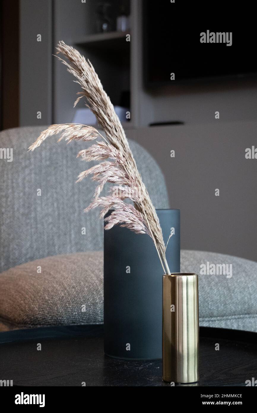 vaso su un tavolino con una sedia in un accogliente interno. Foto Stock