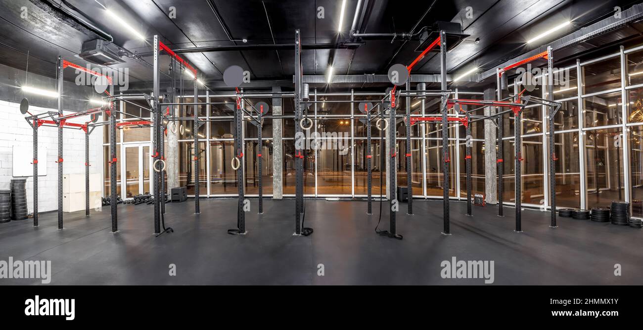 Interno della palestra per allenamento incrociato. Attrezzature per l'allenamento ad alta intensità in ambienti spaziosi. Barre orizzontali, anelli di ginnastica. Sport Foto Stock