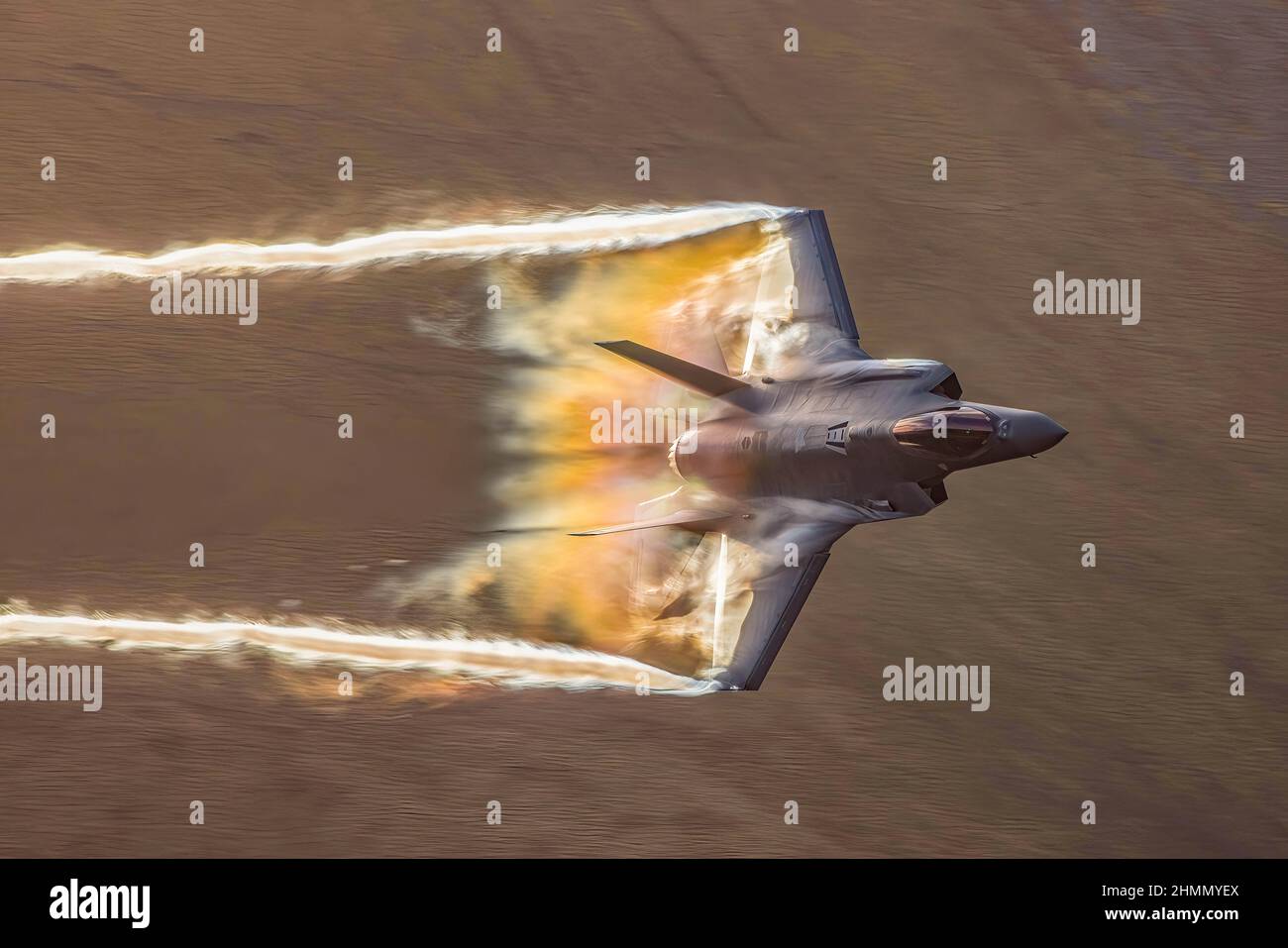 Un USAF Lockheed Martin F-35 Lightning II fa sì che il vapore, noto anche come fluffing, rimbalzi sulle sue ali mentre sfata a 500 nodi durante un sortie di basso livello di allenamento attraverso il Mach Loop. Un'area del Parco Nazionale di Snowdonia in Galles. REGNO UNITO. 10/02/2022 fotografato dal fotografo dell'aviazione locale e della fauna selvatica Thomas Winstone. Foto Stock