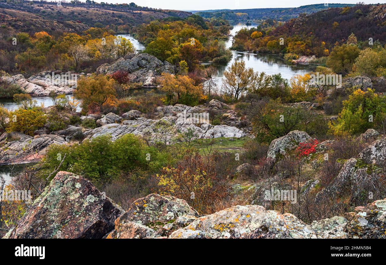Alberi e rocce su un'isola riflessa in un fiume Bug nel parco Bugskiy gard dell'Ucraina (Panorama) Foto Stock
