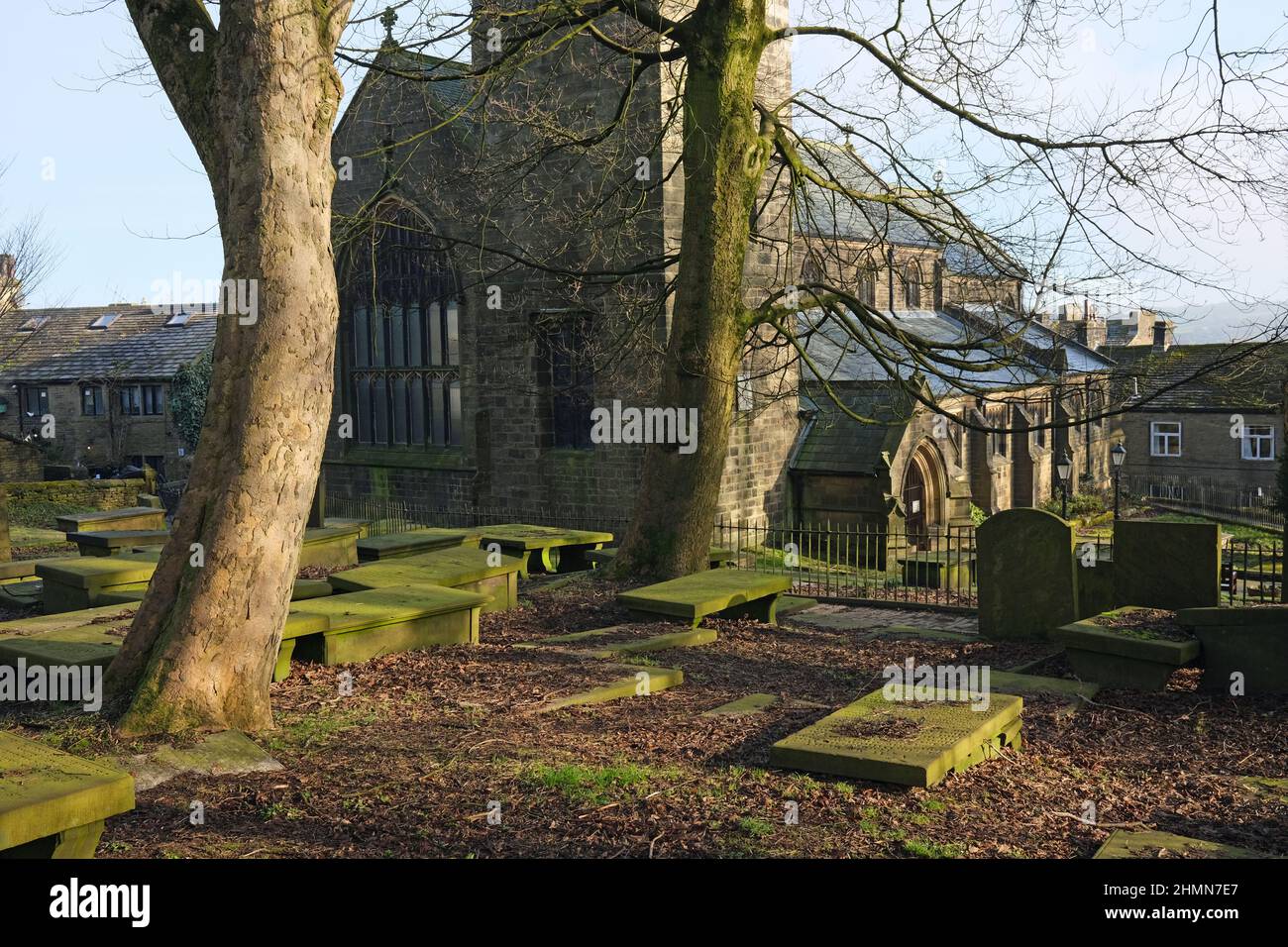 St Michael e tutti gli Angeli Chiesa e cimitero in inverno sole, Haworth, West Yorkshire Foto Stock