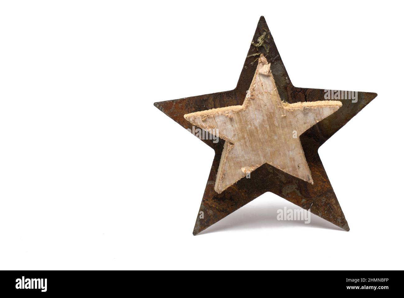 Primo piano di grande stella tagliata in acciaio arrugginito metallo ferro con più piccolo di legno e corteccia di betulla su di esso di fronte su sfondo bianco Foto Stock