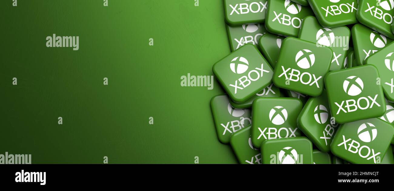 Logo della console di gioco home video Microsoft Xbox su un mucchio su un tavolo. Spazio di copia. Formato banner Web. Foto Stock