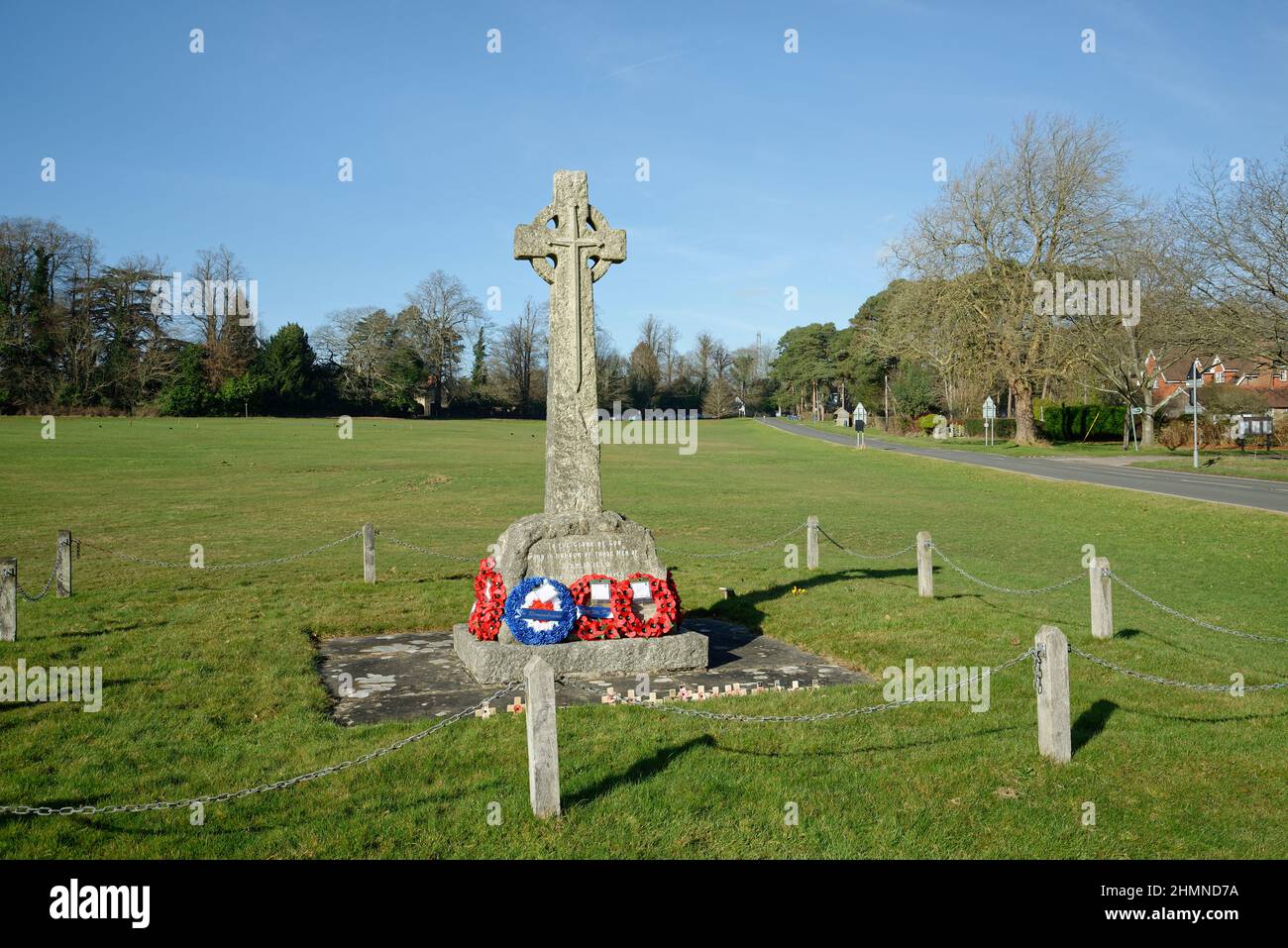 War Memorial a Staplefield Green nel West Sussex. Una croce cristiana con le corone di papavero sotto. Foto Stock