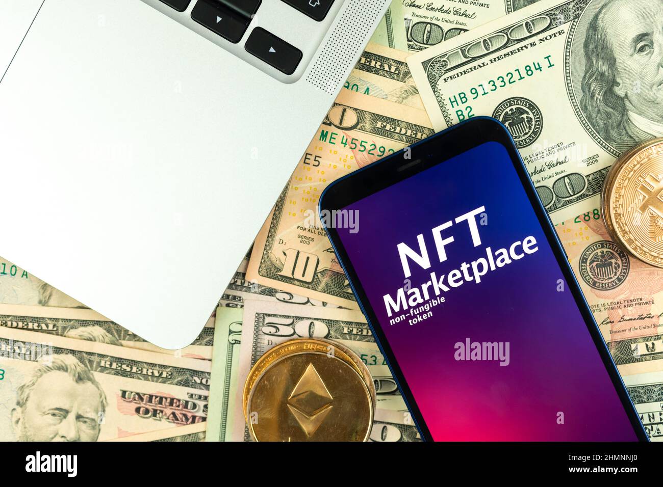 Sfondo del mercato della crittografia NFT. Smartphone con applicazione NFT su sfondo monetario con monete metalliche in cripto dorato, vista dall'alto Foto Stock