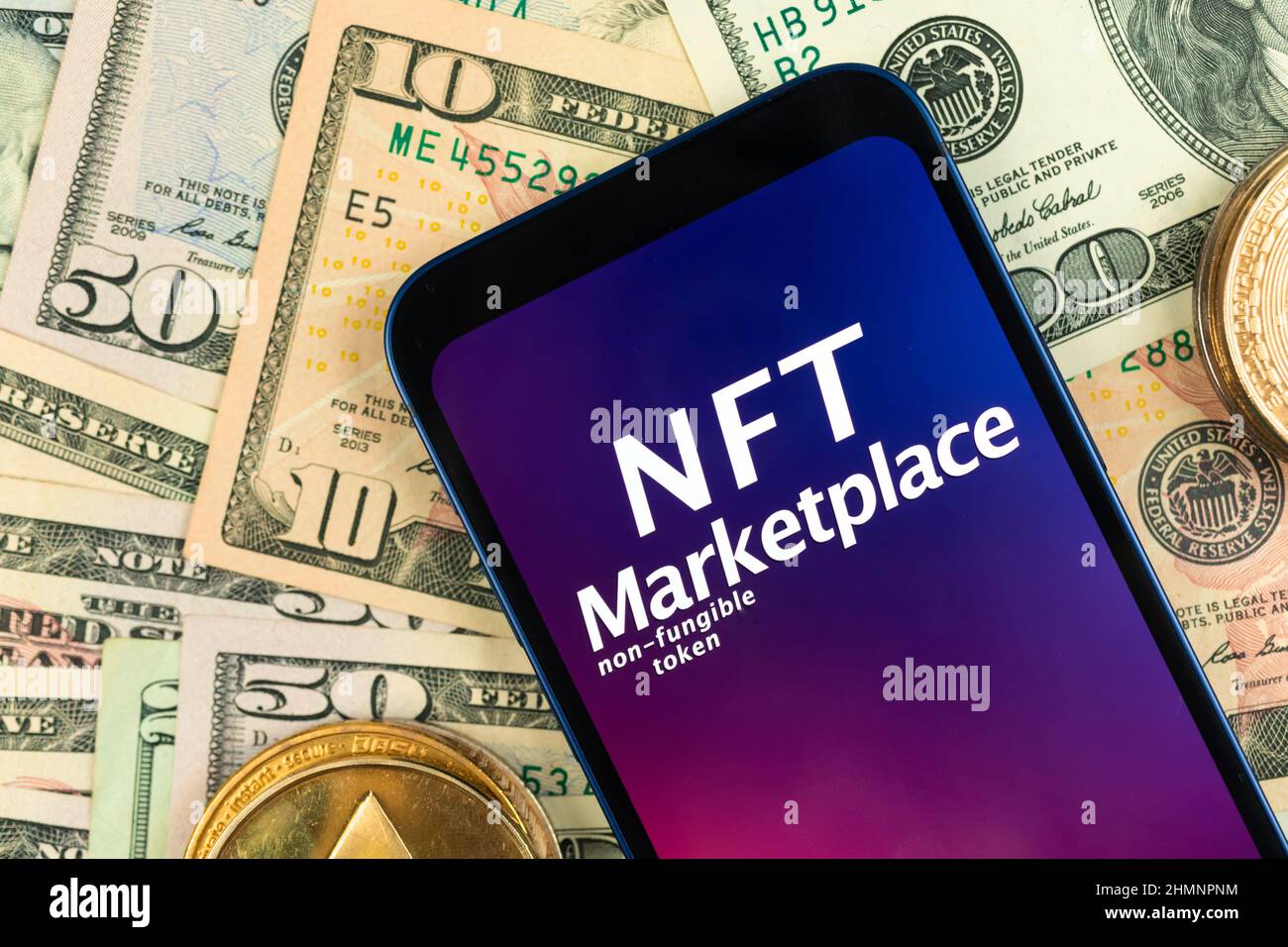 Sfondo del mercato della crittografia NFT. Smartphone con applicazione NFT su sfondo monetario con monete metalliche in cripto dorato, vista dall'alto Foto Stock