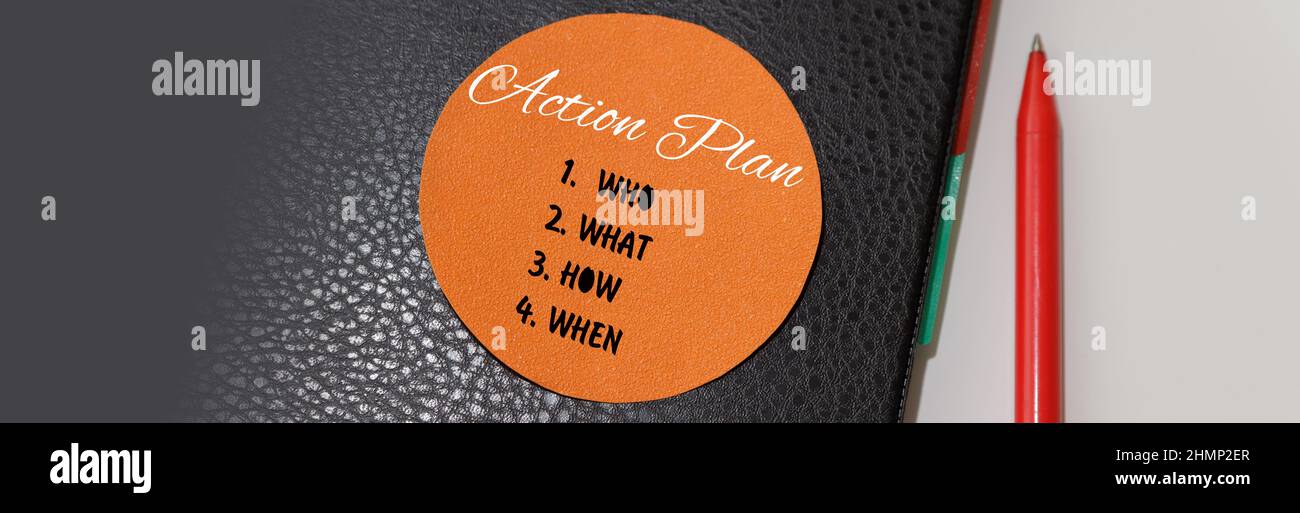 Piano d'azione strategia visione pianificazione direzione concetto. Gestione del tempo. Il testo è scritto su un adesivo rotondo arancione su un notebook nero. Foto Stock