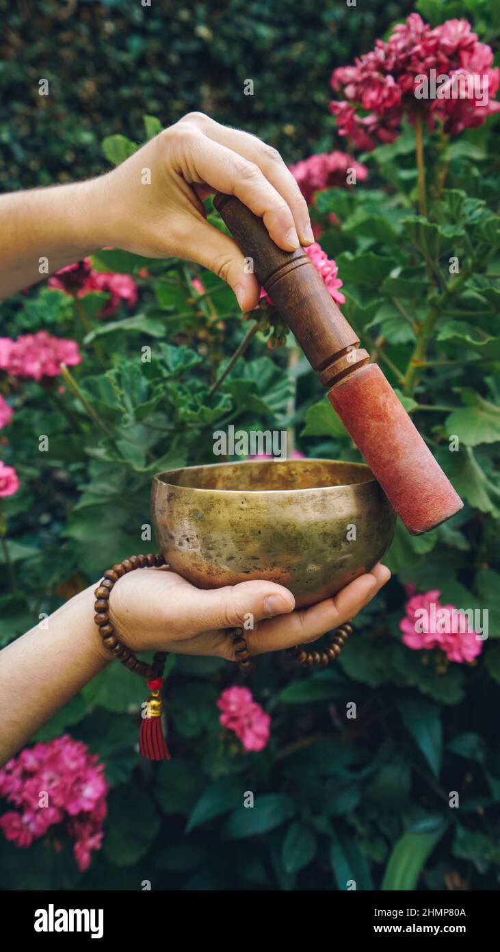 donna non riconosciuta che afferra la ciotola di canto tibetano e japa mala Foto Stock