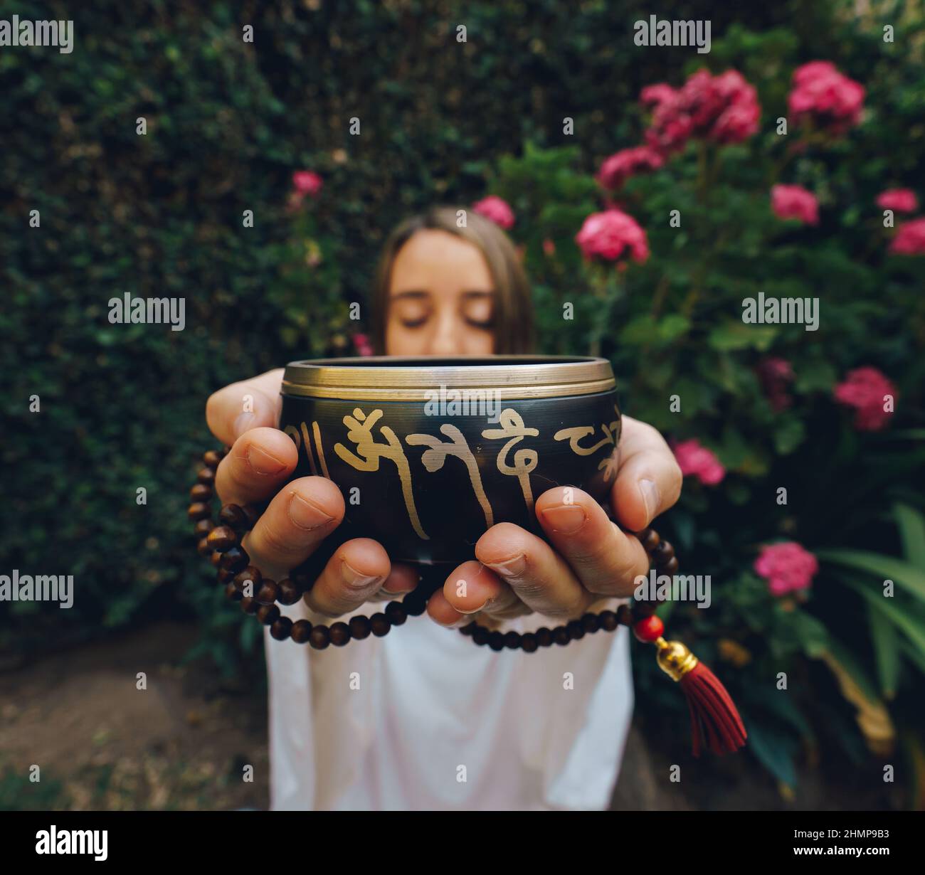 donna che afferra la ciotola di canto tibetano e japa mala Foto Stock