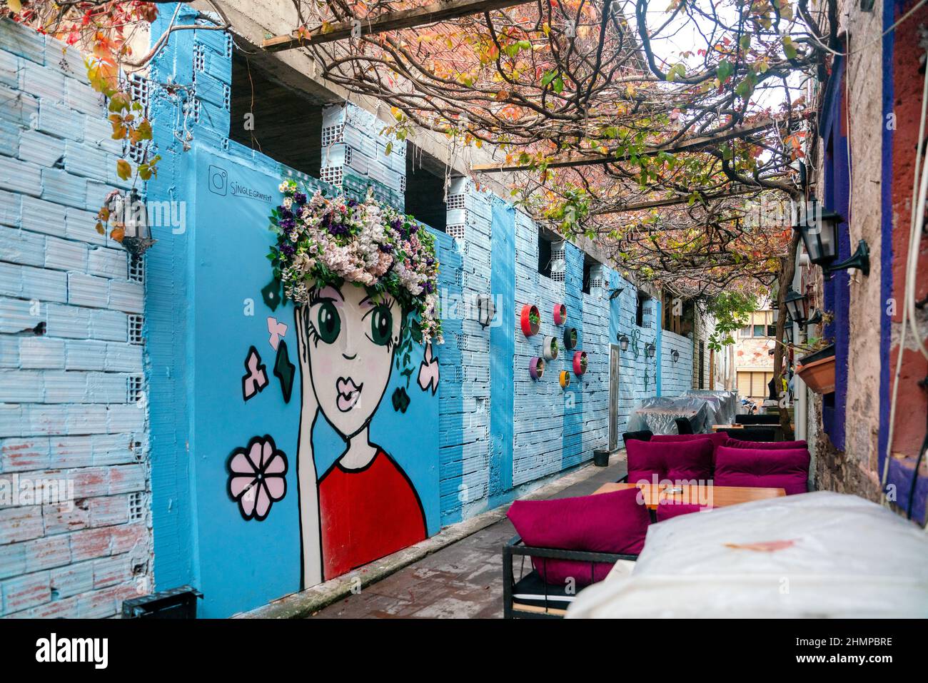 Graffiti sulla recinzione. Disegno di una ragazza su sfondo blu. Bella recinzione sulla strada. Kas, Turchia - 2 Novembre, 2019. Foto Stock