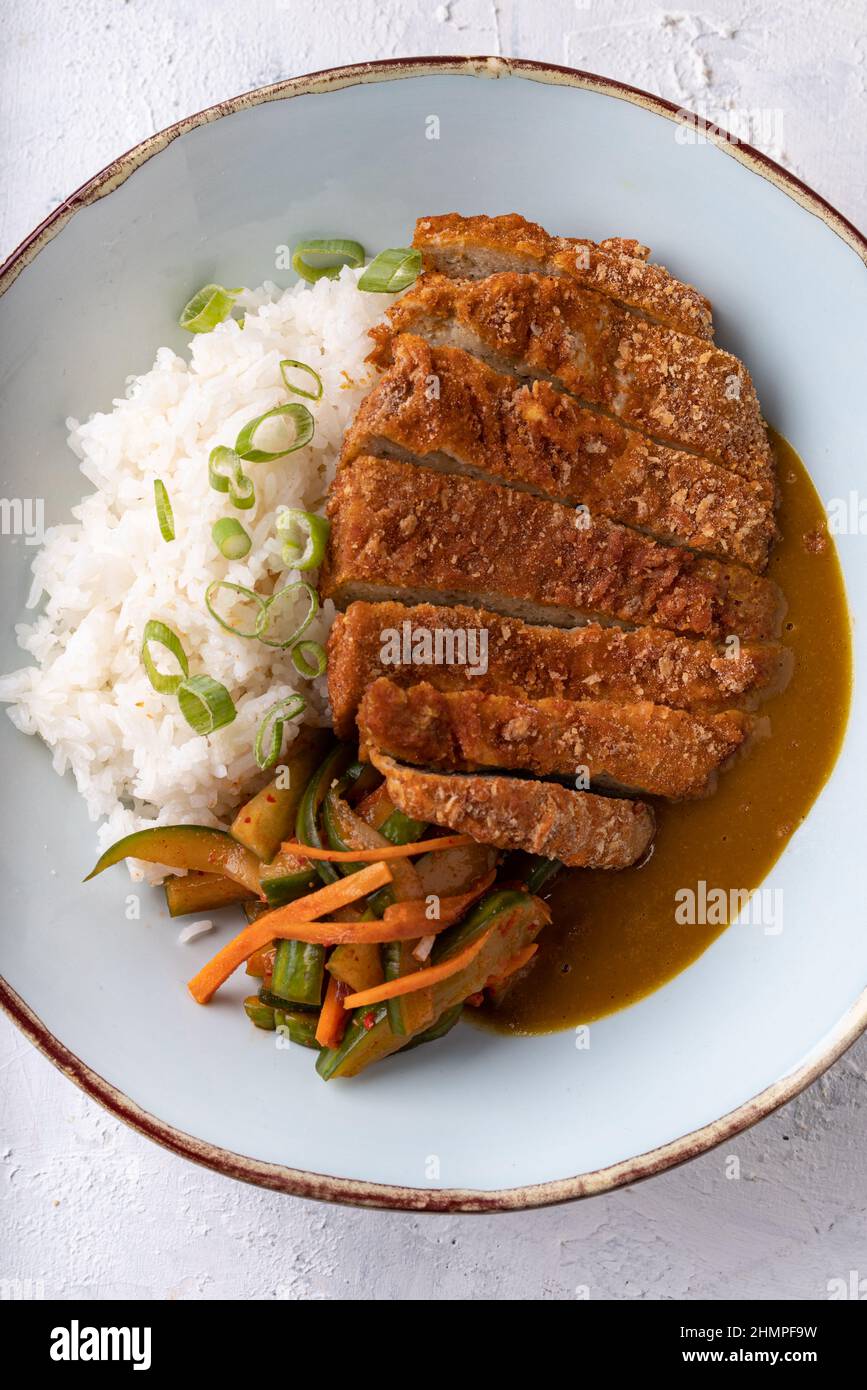 Bistecca di ceci senza carne vegana di fusione asiatica, guarnita con carote, zucchine e riso bianco morbido Foto Stock