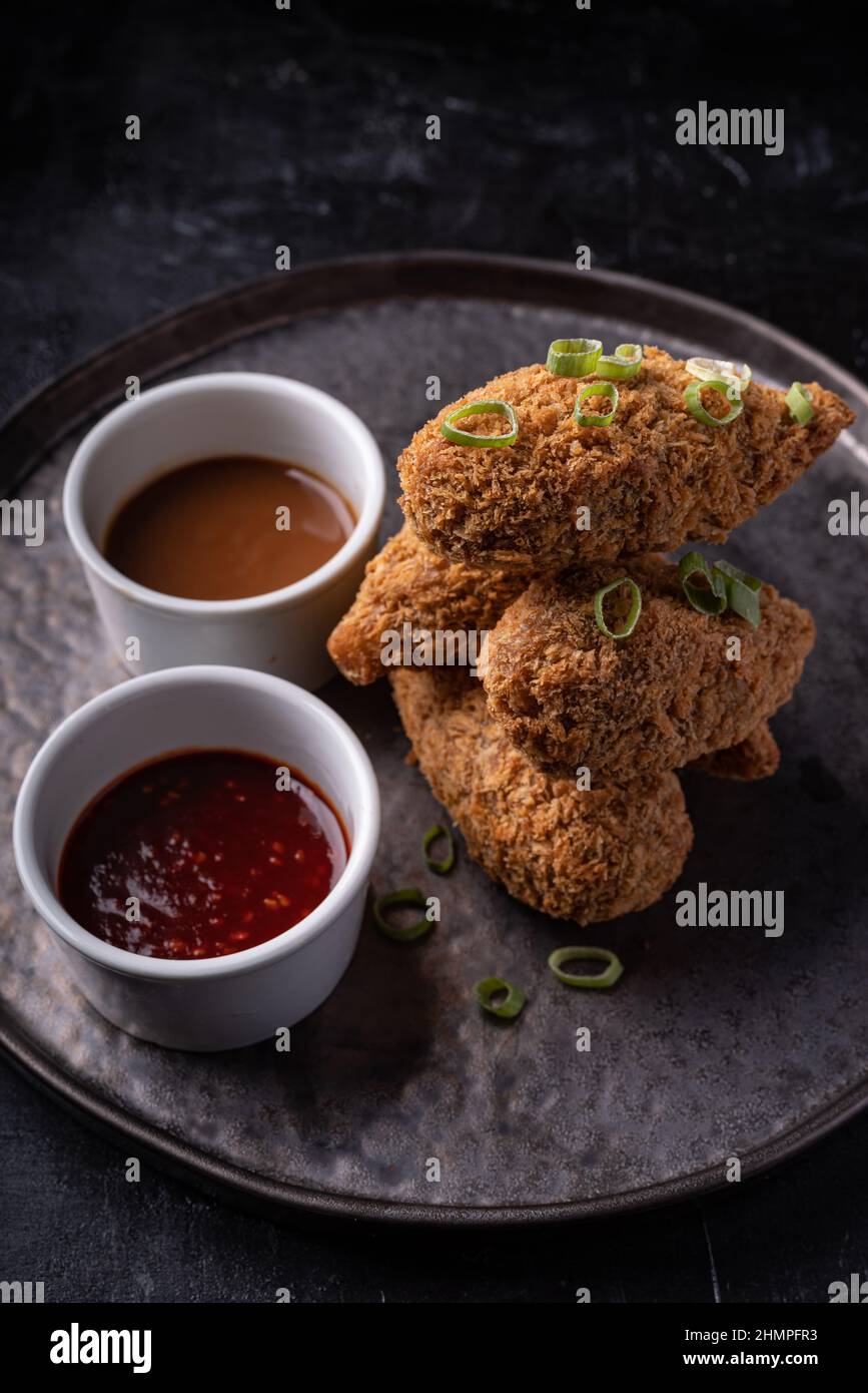 Bastoncini di jackfruit senza carne con salsa di sesamo calda dolce e salsa di barbecue vegano fusion asiatica Foto Stock