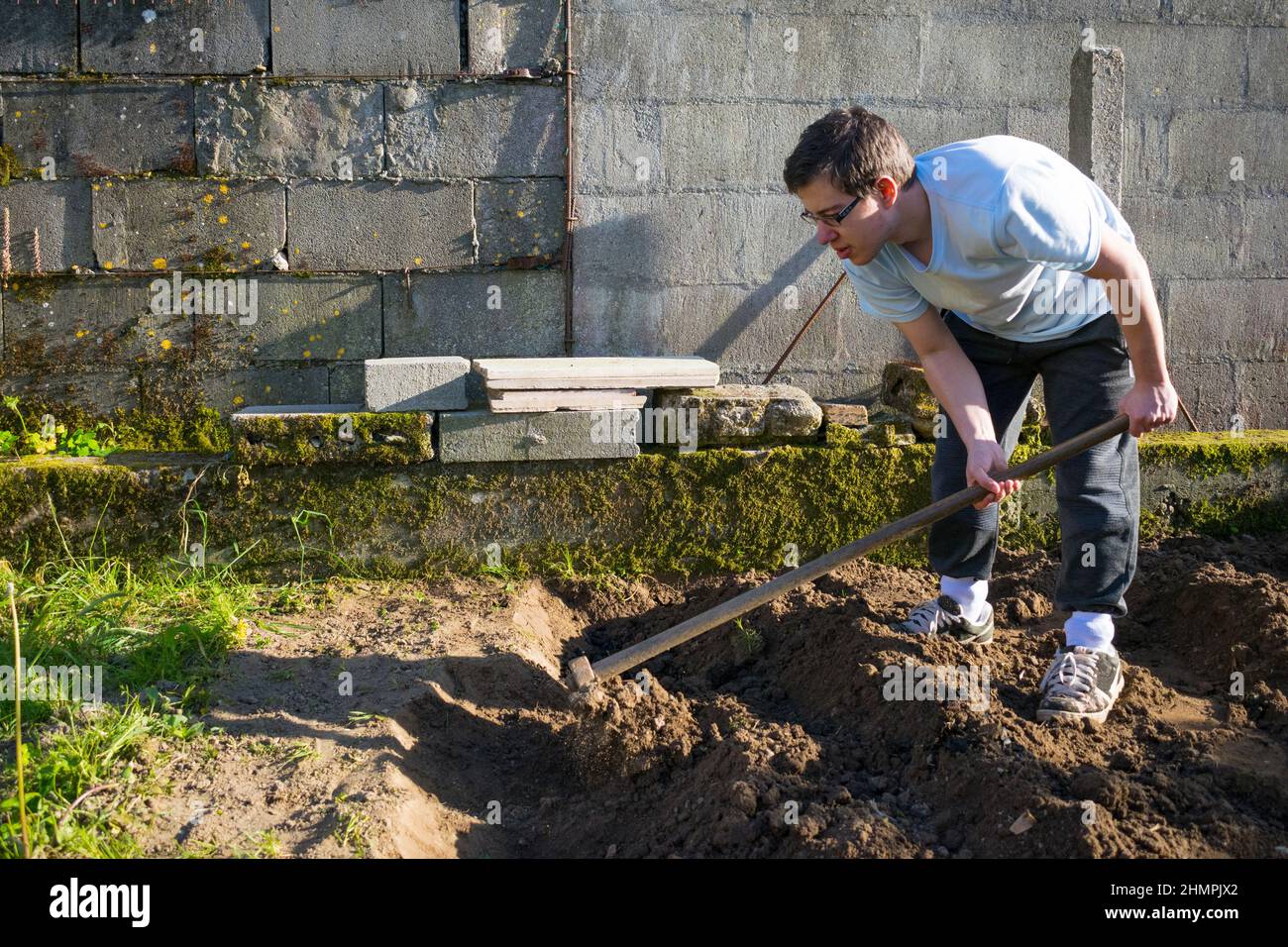 Giovane uomo scavando terreno in un giardino, Spagna Foto Stock