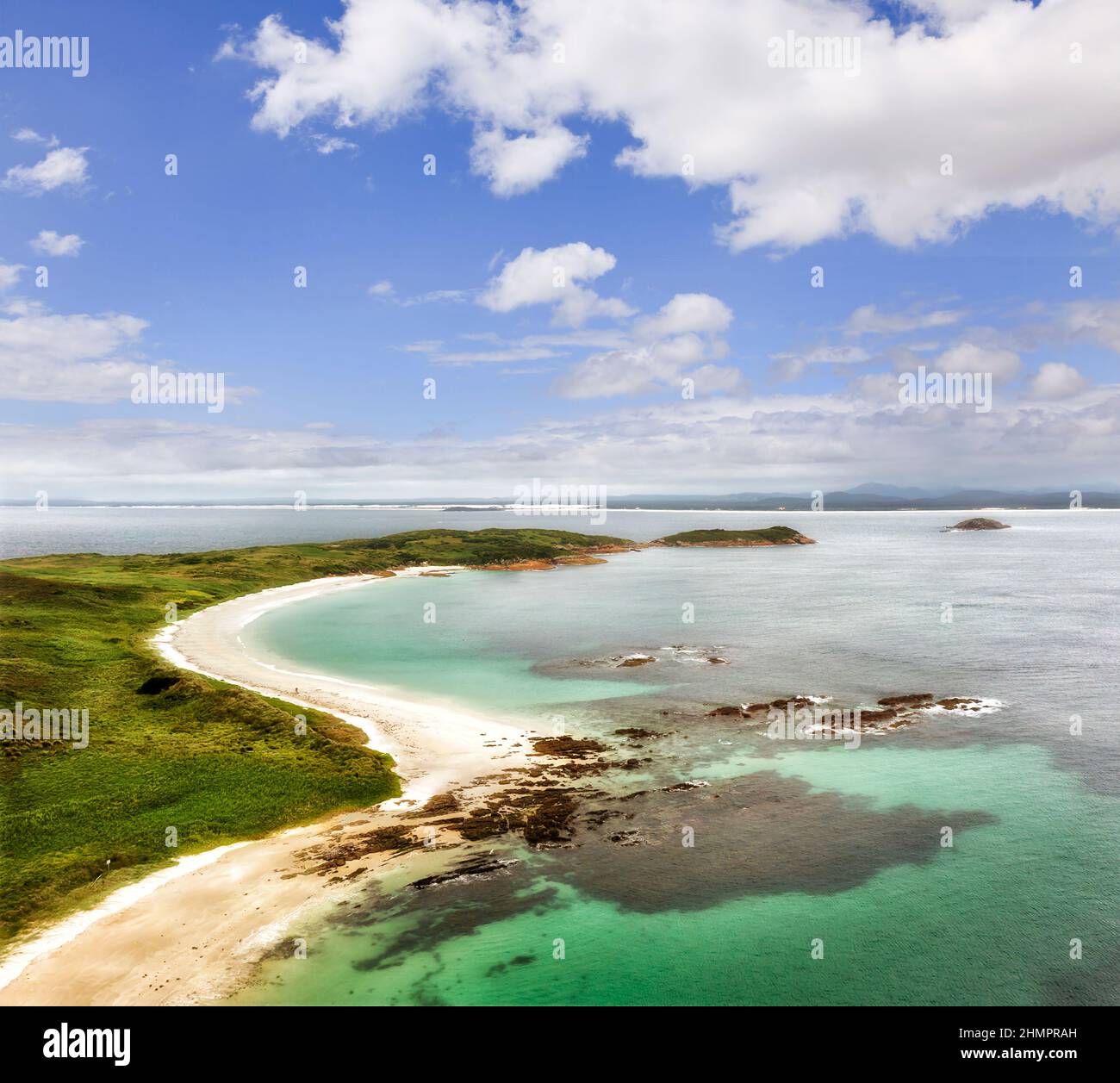 Panoramica remota Broughton isola sulla costa pacifica dell'Australia sotto il cielo blu - mare aereo verso continente. Foto Stock