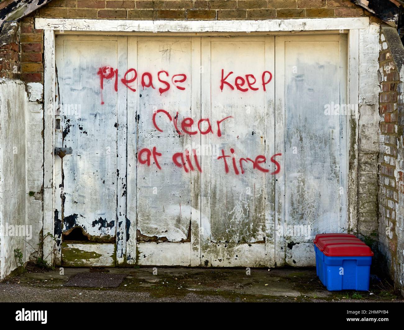 Una porta del garage con le parole si prega di tenere sempre chiaro Foto  stock - Alamy
