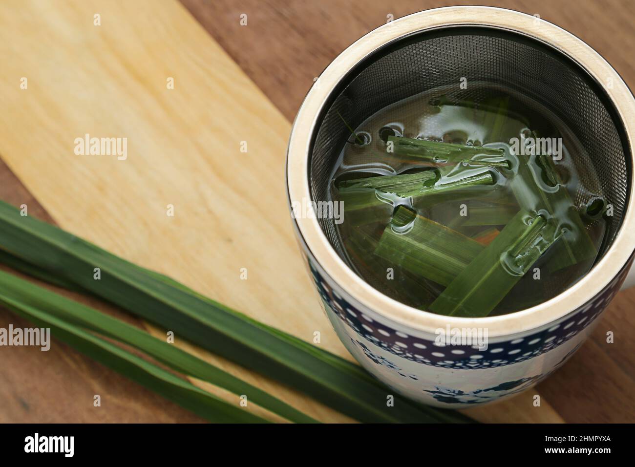 Goiânia, Goias, Brasile – 11 febbraio 2022: Una tazza di tè con foglie di citronella su una superficie di legno. Foto Stock