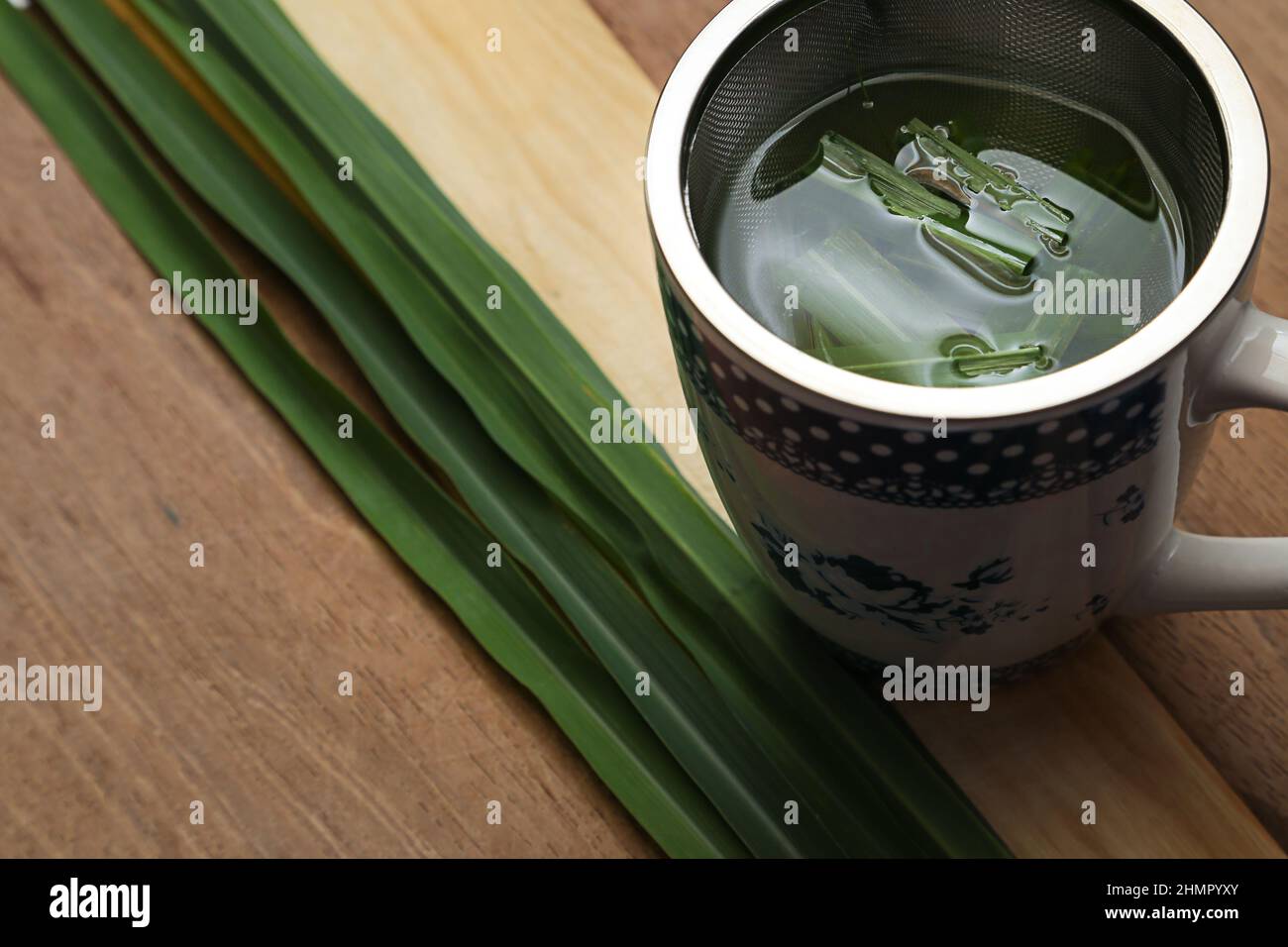 Goiânia, Goias, Brasile – 11 febbraio 2022: Una tazza di tè con foglie di citronella su una superficie di legno. Foto Stock