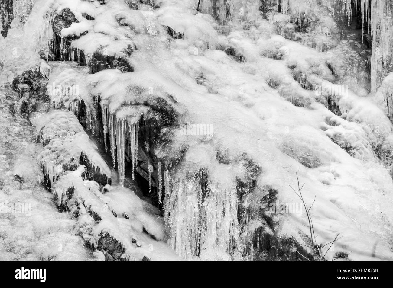 Particolare di cascata ghiacciata con molte ghiacciole. Foto Stock
