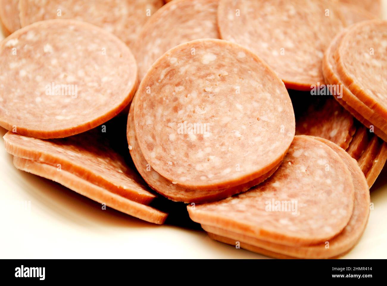 Primo piano delle fette di salame duro in un recipiente bianco Foto Stock