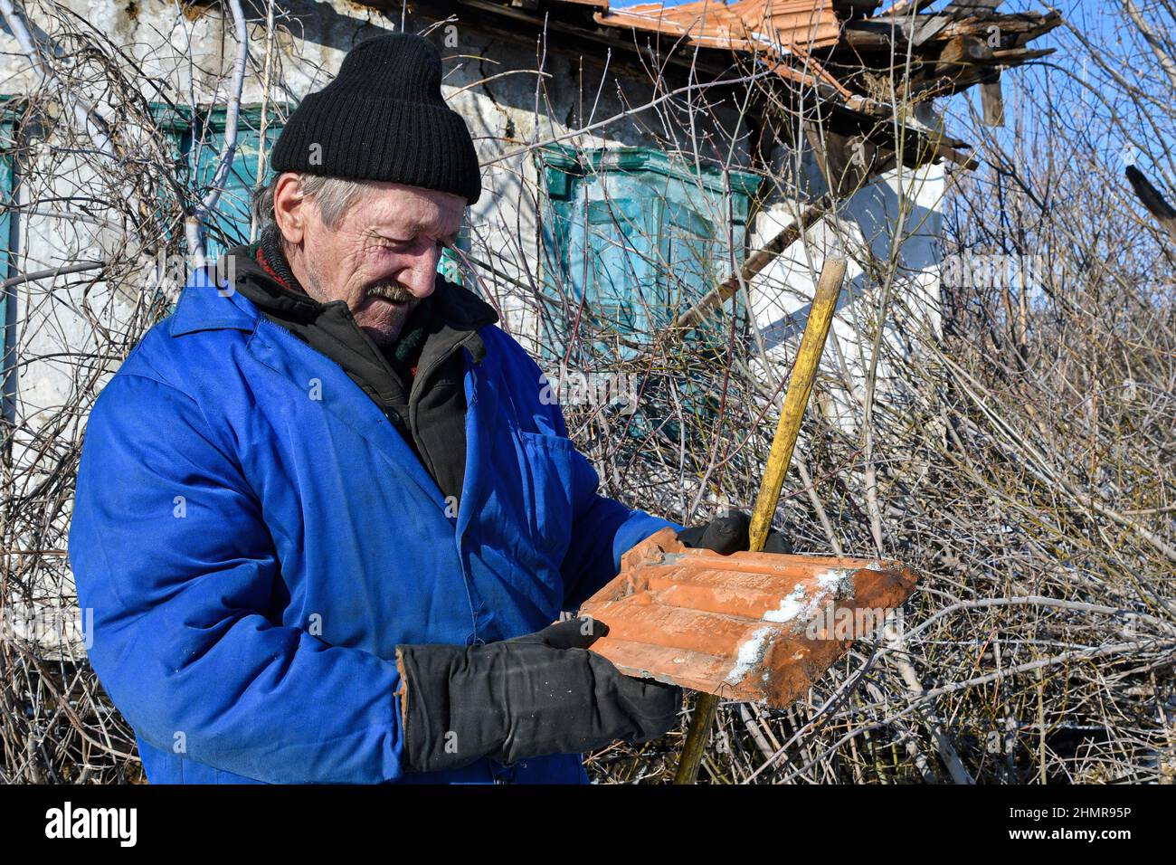 Zaitseve, Donetsk, Ucraina. 5th Feb 2022. Un vecchio uomo sta guardando una vecchia mattonella vicino ai 120 anni distrutti casa abbandonata nella periferia di Zaitseve.il presidente degli Stati Uniti Joe Biden ha invitato tutti i cittadini americani che rimangono in Ucraina a lasciare il paese immediatamente, citando le minacce crescenti di azione militare russa. Egli ha detto che non avrebbe inviato truppe per salvare gli americani se Mosca invade l'Ucraina. Il Cremlino dice che vuole far rispettare le 'linee rosse' per assicurarsi che il suo ex vicino sovietico non aderisca alla NATO (Credit Image: © Andriy Andriyenko/SOPA Images via ZUMA Press Wire) Foto Stock