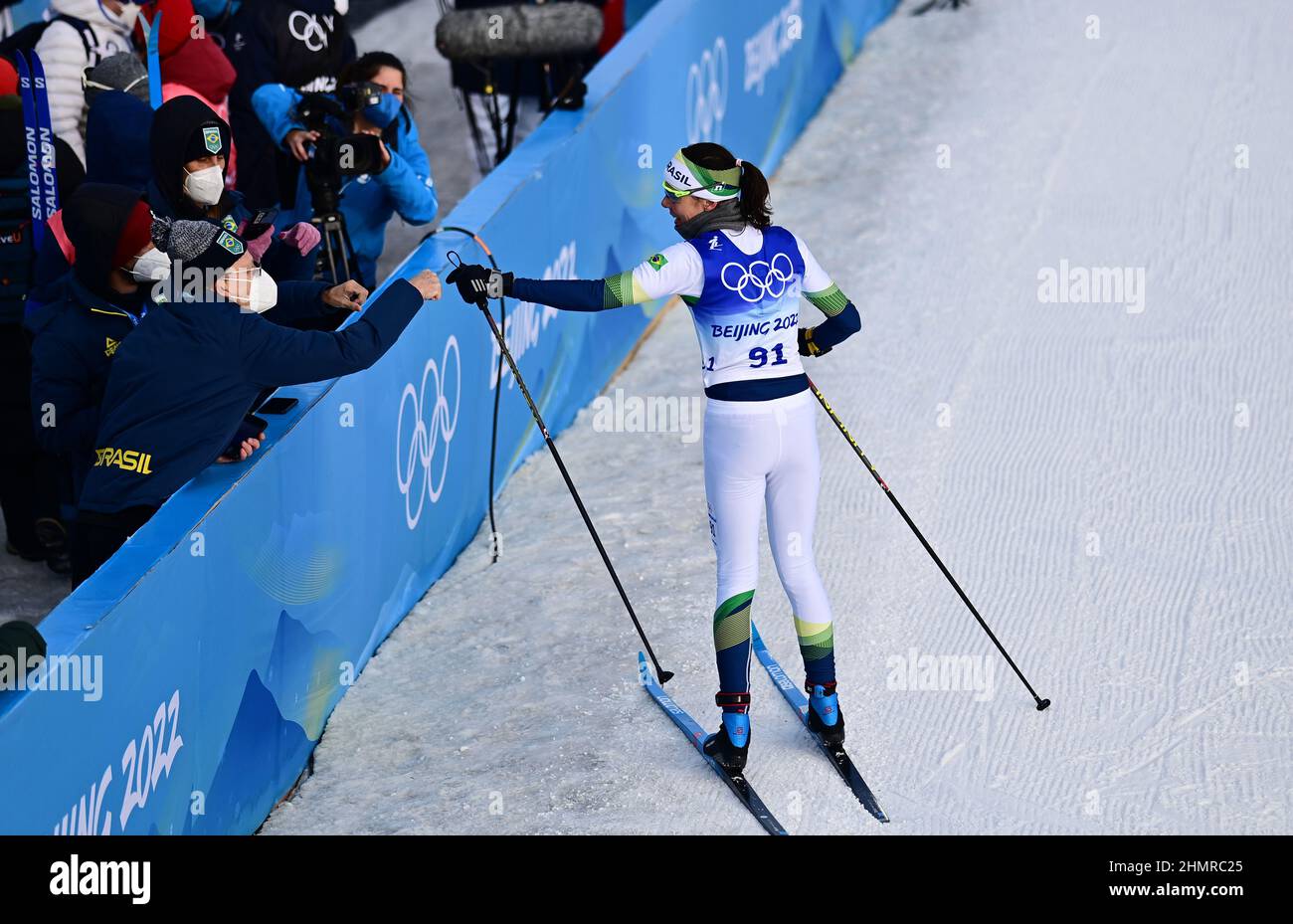 (220212) -- ZHANGJIAKOU, 12 febbraio 2022 (Xinhua) -- Jaqueline Mourao del Brasile (R) saluta con i compagni di squadra e i membri del personale al Centro Nazionale di Sci di fondo a Zhangjiakou, provincia di Hebei della Cina settentrionale, 10 febbraio 2022. Rimettendo piede a Pechino dove ha gareggiato in mountain bike nel 2008, Jaqueline Mourao ha creato la storia come primo atleta brasiliano a competere ai Giochi Olimpici otto volte dal suo debutto olimpico ad Atene 2004, Ed è anche la prima atleta brasiliana a gareggiarsi sia alle Olimpiadi estive che invernali.'nel 2008, non ero un atleta molto maturo, mentalmente,' Mourao Foto Stock