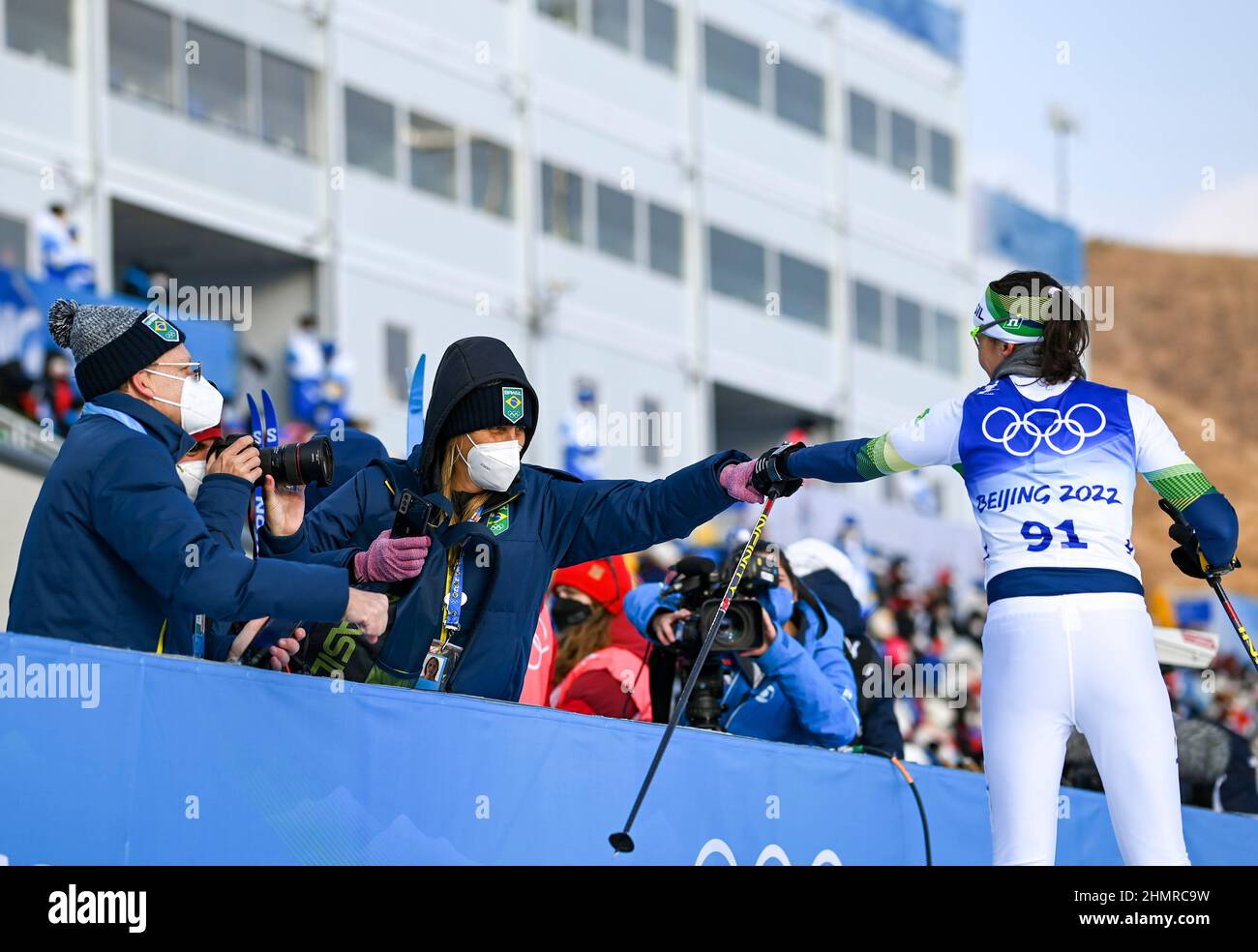 (220212) -- ZHANGJIAKOU, 12 febbraio 2022 (Xinhua) -- Jaqueline Mourao del Brasile (1st R) saluta con i compagni di squadra e i membri del personale al Centro Nazionale di Sci di fondo a Zhangjiakou, provincia di Hebei della Cina settentrionale, 10 febbraio 2022. Rimettendo piede a Pechino dove ha gareggiato in mountain bike nel 2008, Jaqueline Mourao ha creato la storia come primo atleta brasiliano a competere ai Giochi Olimpici otto volte dal suo debutto olimpico ad Atene 2004, Ed è anche la prima atleta brasiliana a gareggiarsi sia alle Olimpiadi estive che invernali.'nel 2008, non ero un atleta molto maturo, mentalmente,' Mo Foto Stock