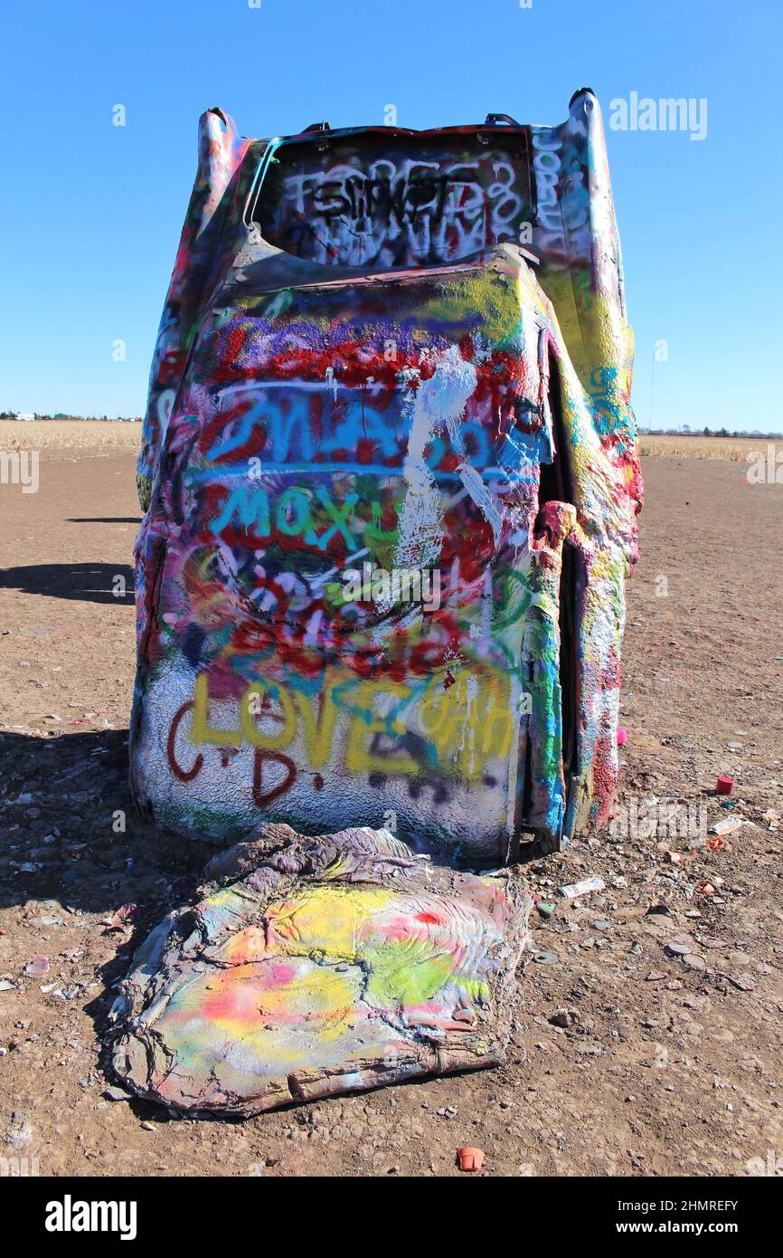 Cadillac Ranch ad Amarillo, Texas, dove 10 Cadillac diversi sono sepolti naso prima nel terreno. Si consiglia la verniciatura a spruzzo. Foto Stock