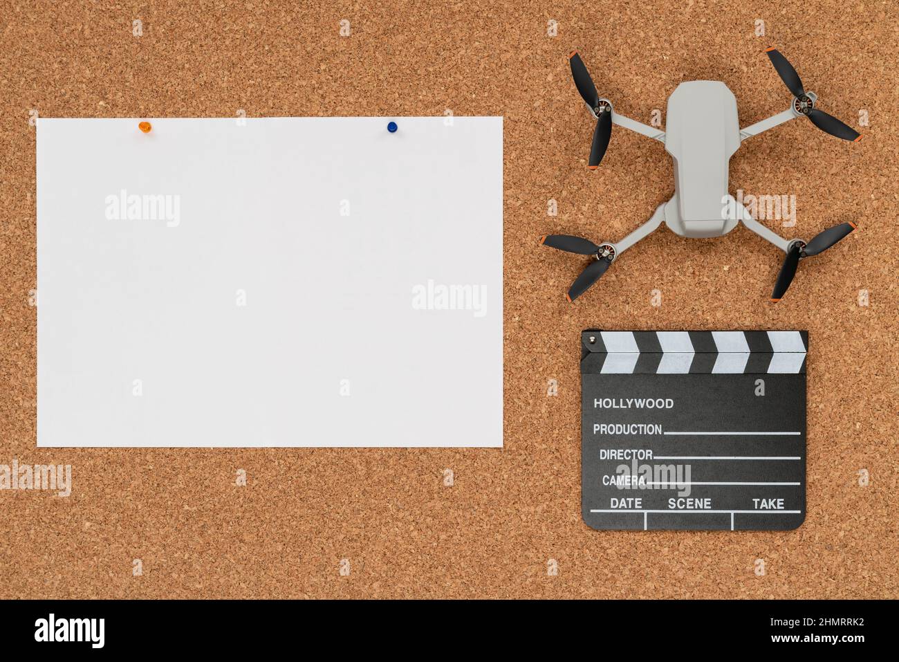 Sughero sfondo con un grande carta bianca, un piccolo drone e un clapboard Foto Stock