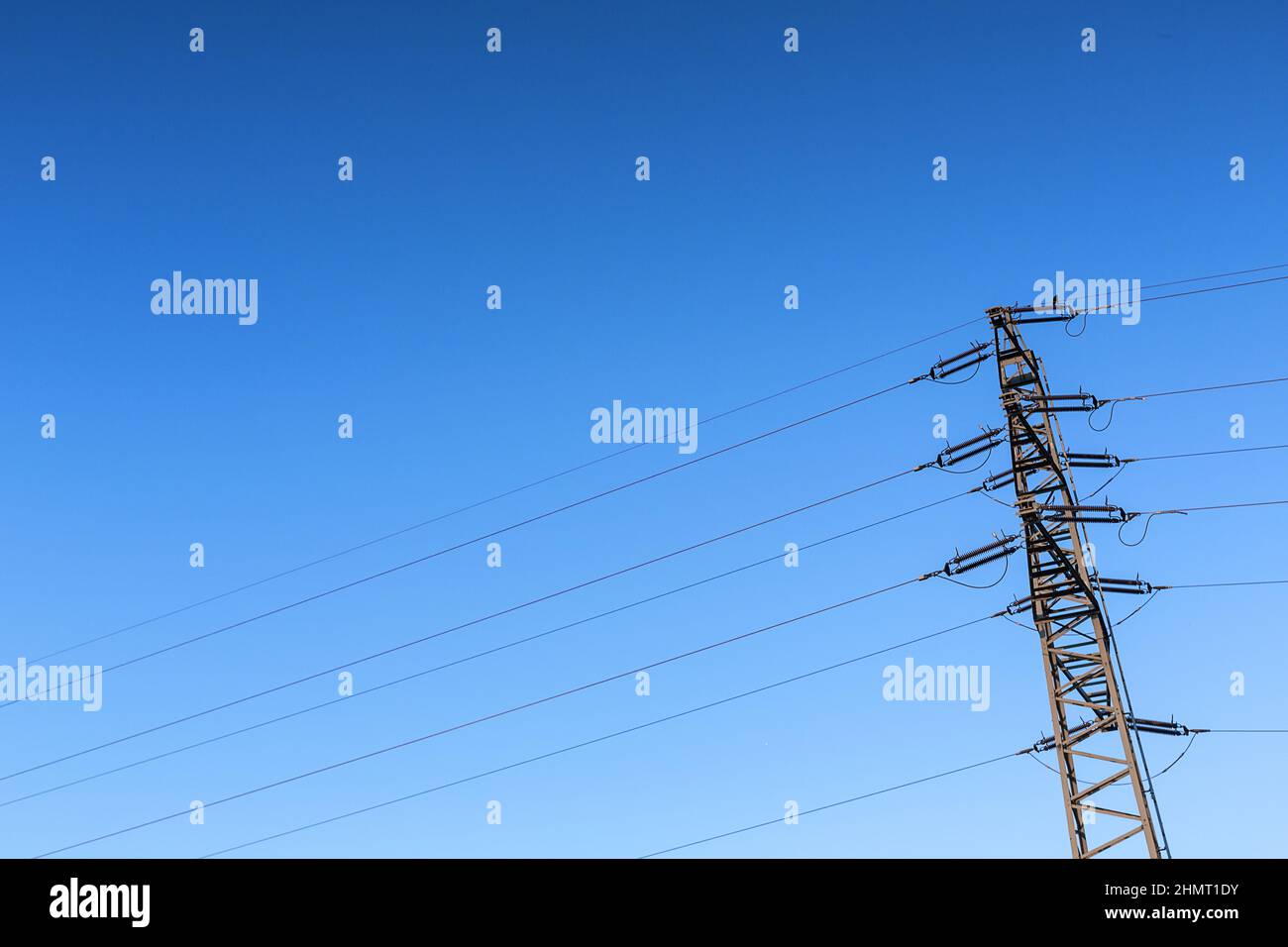 Pilone dell polo di potenza ad alta tensione contro il cielo blu Foto Stock